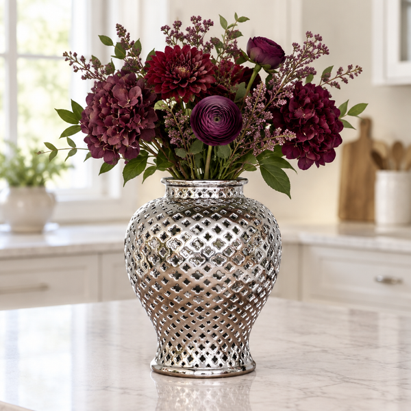 Open silver ceramic lattice ginger jar holding burgundy flowers, with the lid removed