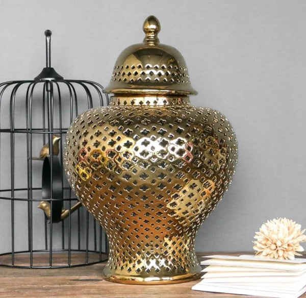 Gold ceramic lattice ginger jar styled with bird cage and dried flower on wood surface