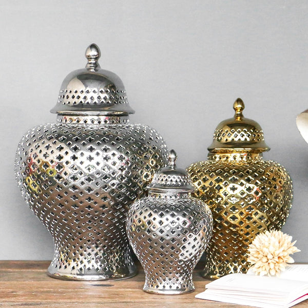 Silver and gold ceramic lattice ginger jars in three sizes on a wood surface