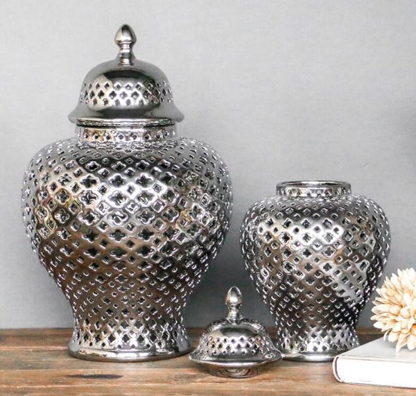 Silver ceramic lattice ginger jars — large with lid on and medium with lid removed on wood surface